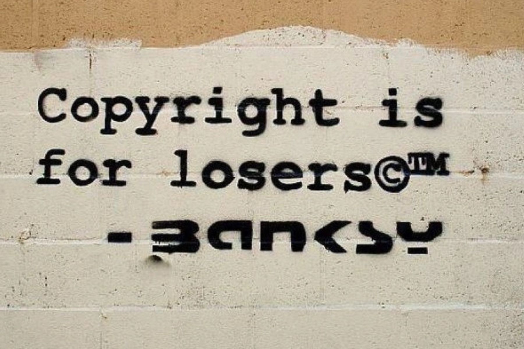 banksy-quote-nyc-wall-the-lawless-muse Graffiti text reading “Copyright is for losers” on a gritty NYC wall